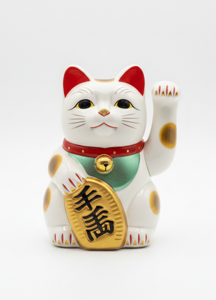 Japanese maneki-neko lucky cat figurine in white and gold with raised paw